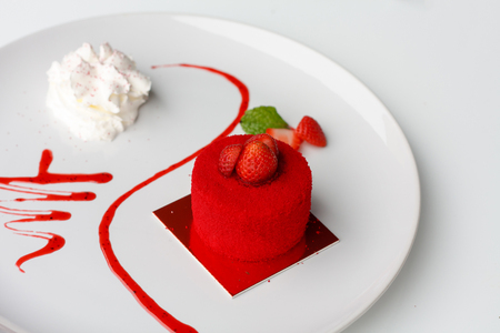 sweet strawberry cake with whipped cream on white plateの写真素材