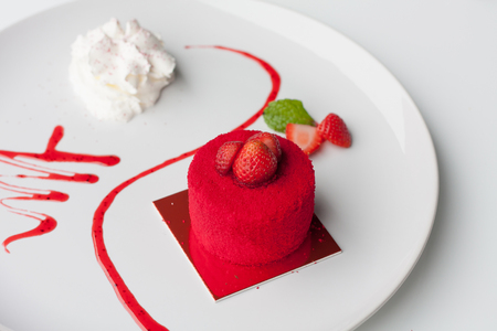 sweet strawberry cake with whipped cream on white plateの写真素材