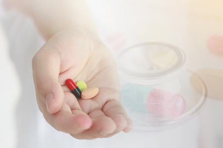 Medical background, female doctor hand holding medicine pills, doctor giving medicine pillsの写真素材