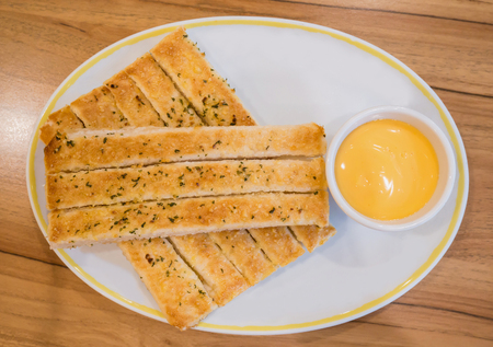 Fresh breadsticks served with dip sauce on white plateの写真素材