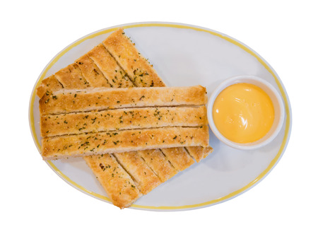 Fresh breadsticks served with dip sauce on white plate isolated on whiteの写真素材