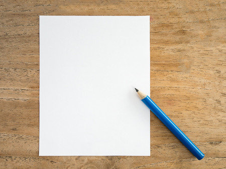 Blank white paper with pencil on wood tableの写真素材