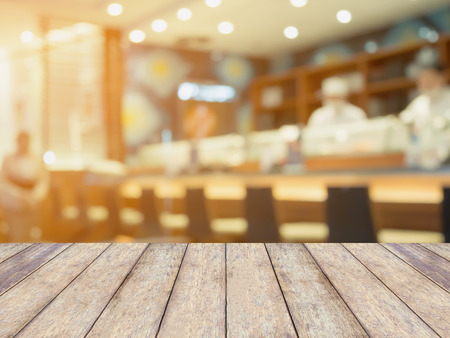 wood table with japanese restaurant and sushi bar interior with chef and customers blur backgroundの写真素材