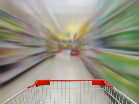supermarket shelves aisle blurred background with shopping cart in motionの写真素材