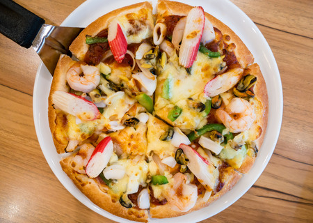 delicious pizza with seafood on wooden tableの写真素材