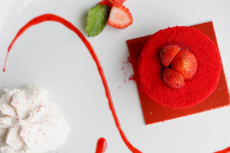 sweet strawberry cake with whipped cream on white plateの写真素材