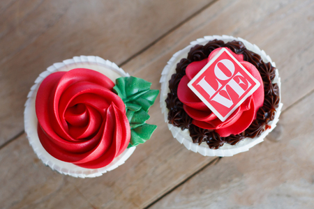 valentines red rose cupcakes on wooden tableの写真素材