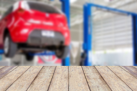 Wood table top with blur car service centre background, for product display or montage your productsの写真素材