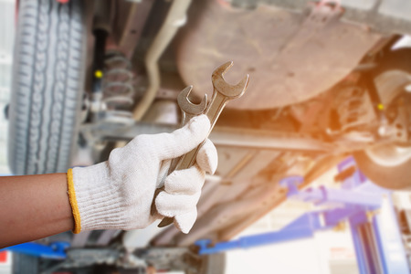 Car mechanic holding wrench at the car repair service garageの写真素材