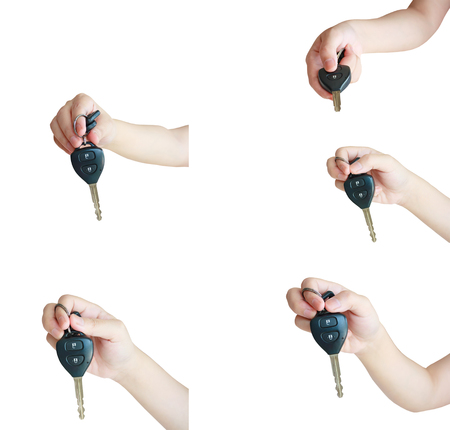 Asian female hand holding car key isolated on white backgroundの写真素材