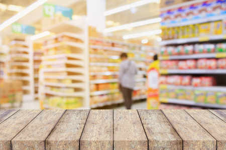 wood table on Supermarket interior blur background with customersの写真素材