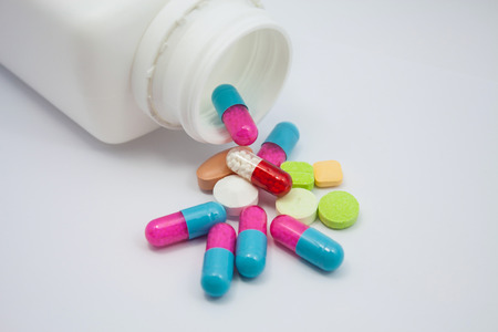 Colored pills, tablets and capsules on white backgroundの写真素材