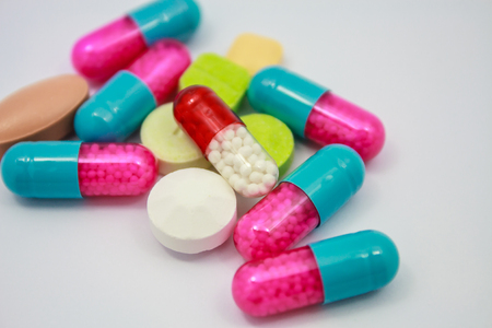Colored pills, tablets and capsules on white backgroundの写真素材