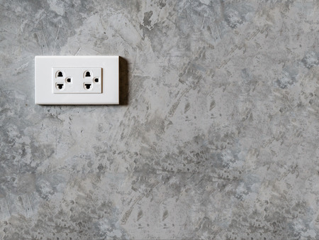 white plug socket on the room wall