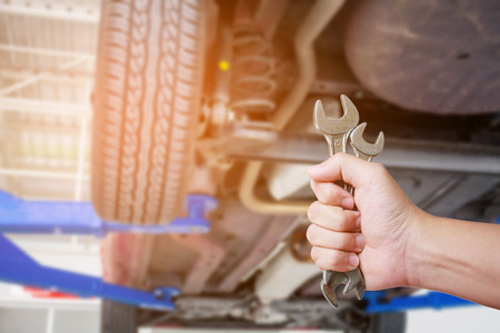 Car mechanic holding wrench at the car repair service garageの写真素材
