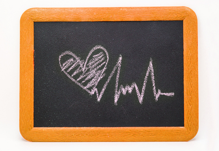 Heartbeat sign, love heart on a chalkboard isolated on white backgroundの写真素材