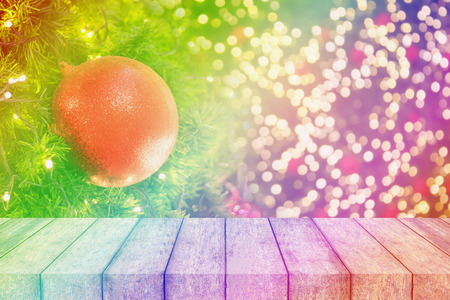 wood table on christmas background with decorations on christmas tree with bokeh light and copy spaceの写真素材