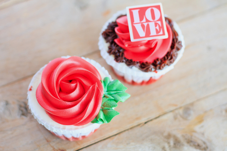 valentines red rose cupcakes on wooden tableの写真素材