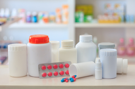 Composition of medicine bottles and pills with pharmacy store shelves backgroundの写真素材