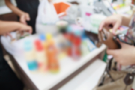 convenience store cashier with customers blur backgroundの写真素材