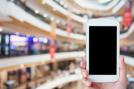 hand hold mobile phone in shopping mall, online shopping conceptの写真素材