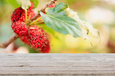 wood table with red mulberries background, product displayの写真素材