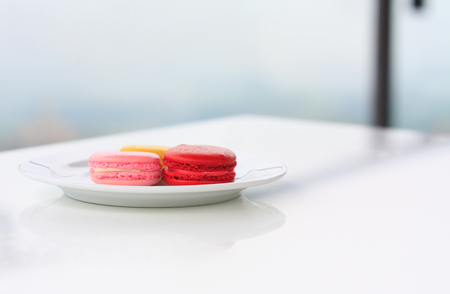 Sweet and colourful french macarons on white tableの写真素材