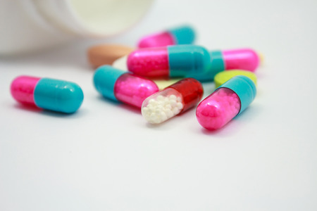 Colored pills, tablets and capsules on white backgroundの写真素材