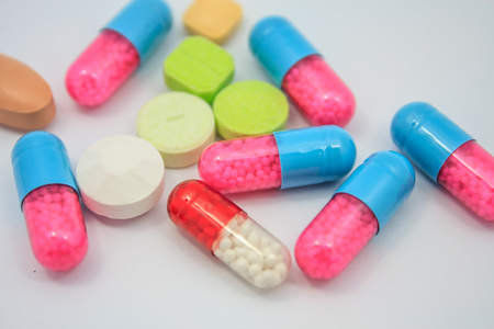 Colored pills, tablets and capsules on white backgroundの写真素材
