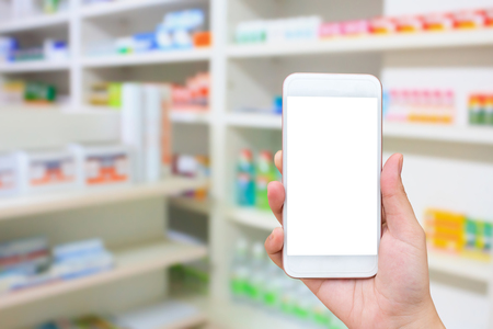 Woman hand using mobile smartphone in the pharmacyの写真素材