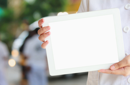 female doctor hold tablet computer with ambulance responding to emergency call blurred backgroundの写真素材