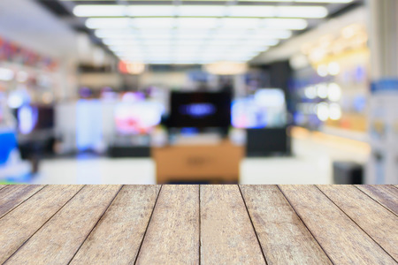 wood table with eletronic department store with bokeh blurred backgroundの写真素材