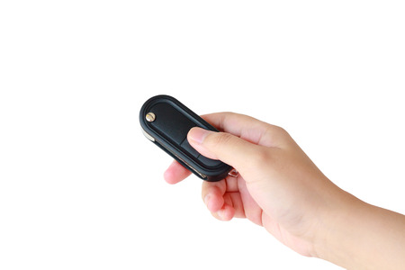women hand presses on the remote control car key alarm systems isolated on white backgroundの写真素材
