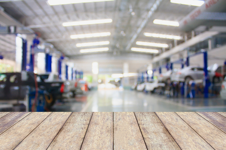 Wood table top with blur garage background, for product display or montage your productsの写真素材