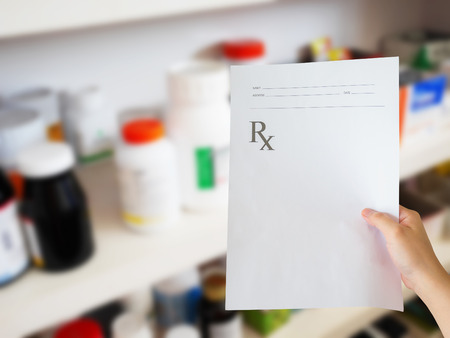 pharmacist hand with prescription at the pharmacyの写真素材