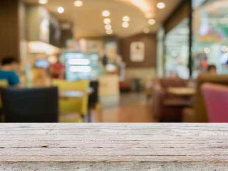 wood table with blur cafe restaurant, coffee shop with abstract bokeh light backgroundの写真素材