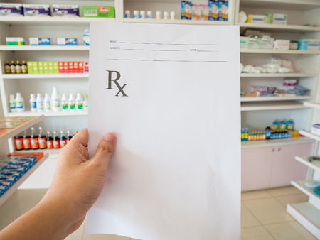 closeup hand of pharmacist with prescription at the pharmacyの写真素材