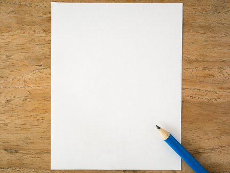 Blank white paper with pencil on wood tableの写真素材
