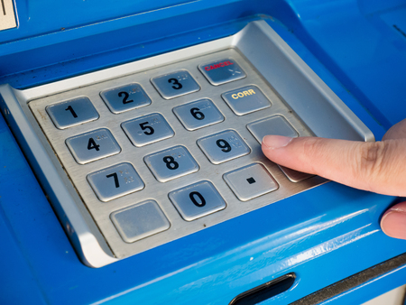 woman using ATM machine to withdraw money, woman press on ATM keyboard to entering PIN or pass code on ATM bank machineの写真素材