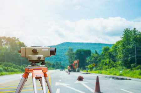 Surveyor equipment tacheometer or theodolite with road construction site backgroundの写真素材