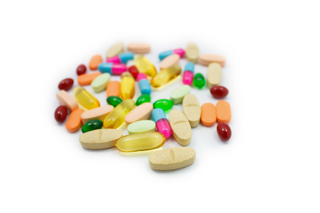 Many colorful pills on white background