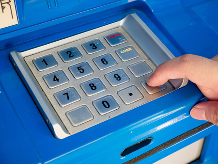 woman using ATM machine to withdraw money, woman press on ATM keyboard to entering PIN or pass code on ATM bank machineの写真素材
