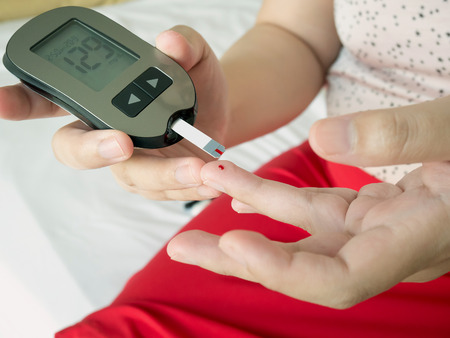 asian woman measuring glucose level with digital glucose meter, diabetes testの写真素材