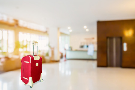 colorful suitcase with hotel lobby blur background, travel conceptの写真素材