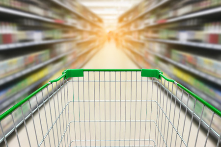 shopping cart with blur background of wine bottles on liquor shelves in supermarket storeの写真素材