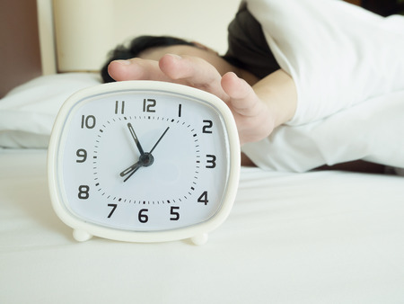 white alarm clock and sleeping woman, vintage toneの写真素材