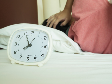 white alarm clock and sleeping man, vintage toneの写真素材