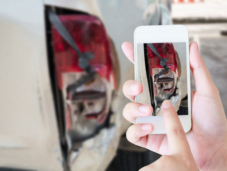 woman using smart phone to take car damage photo caused by car crash accident, car insurance concept
