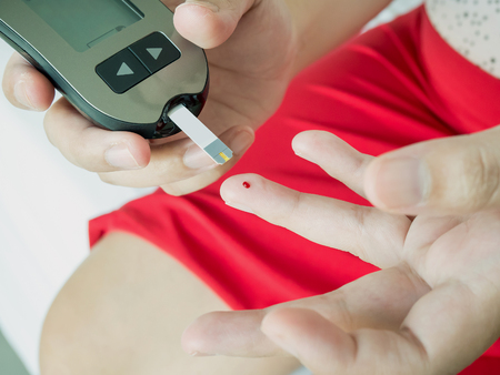 asian woman measuring glucose level with digital glucose meter, diabetes testの写真素材