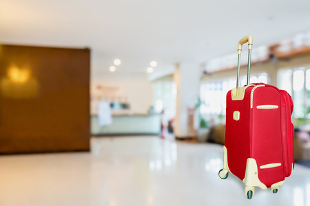 colorful suitcase with hotel lobby blur background, travel conceptの写真素材